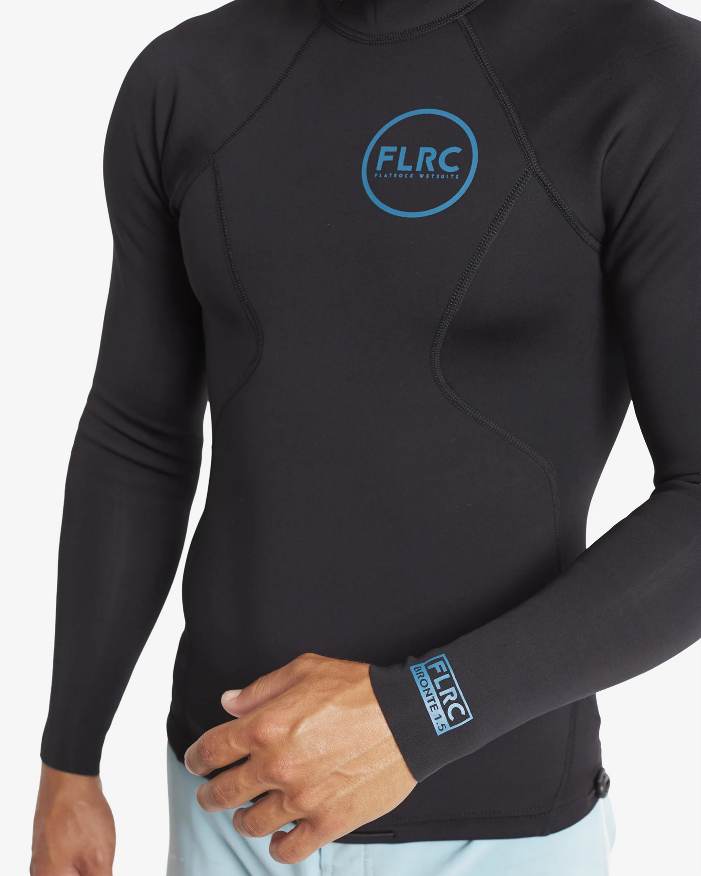Close-up of black FLRC 1.5mm wetsuit top with blue logo, showing front detail.
