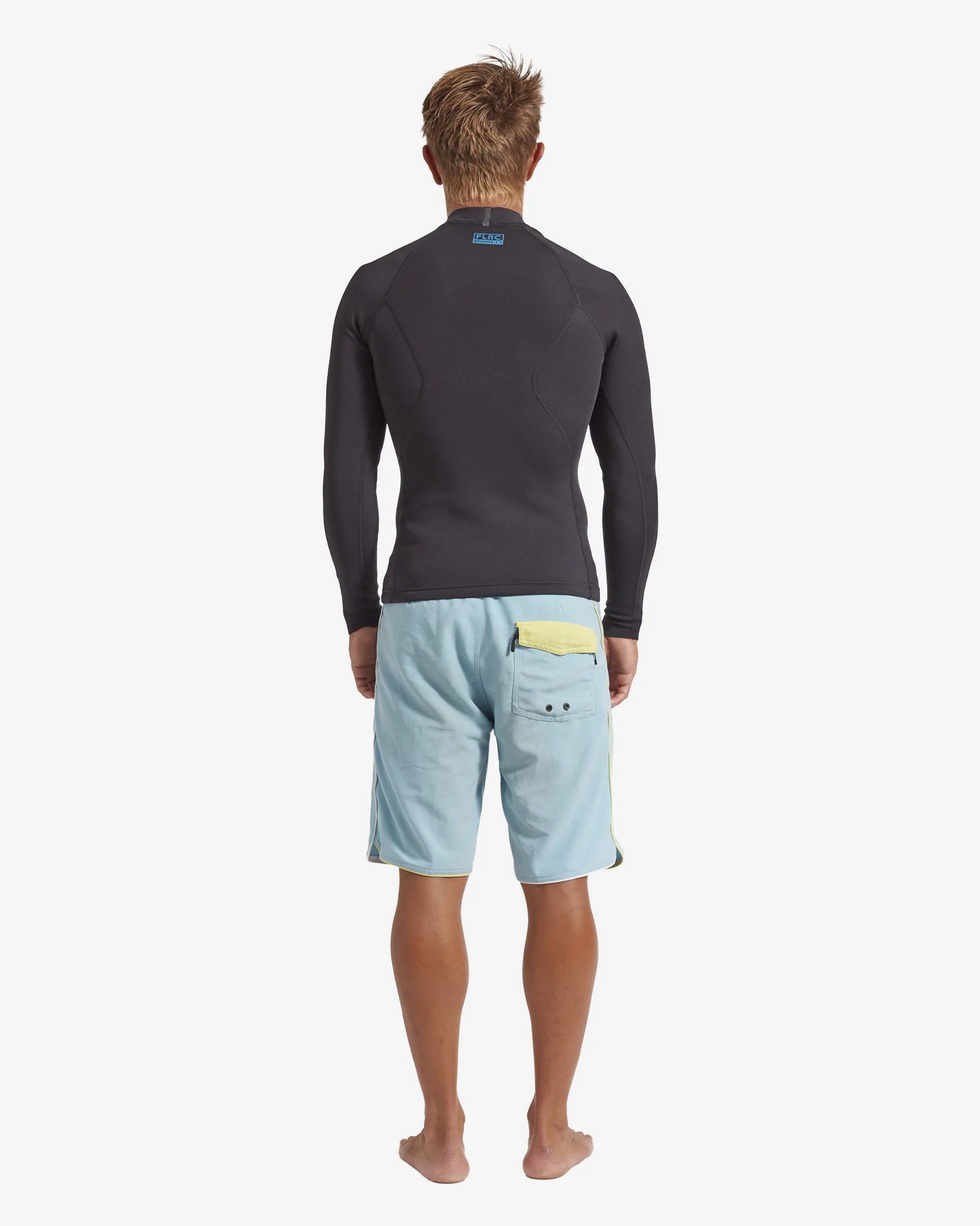 Man wearing black FLRC 1.5mm wetsuit top with blue logo, back view in studio.