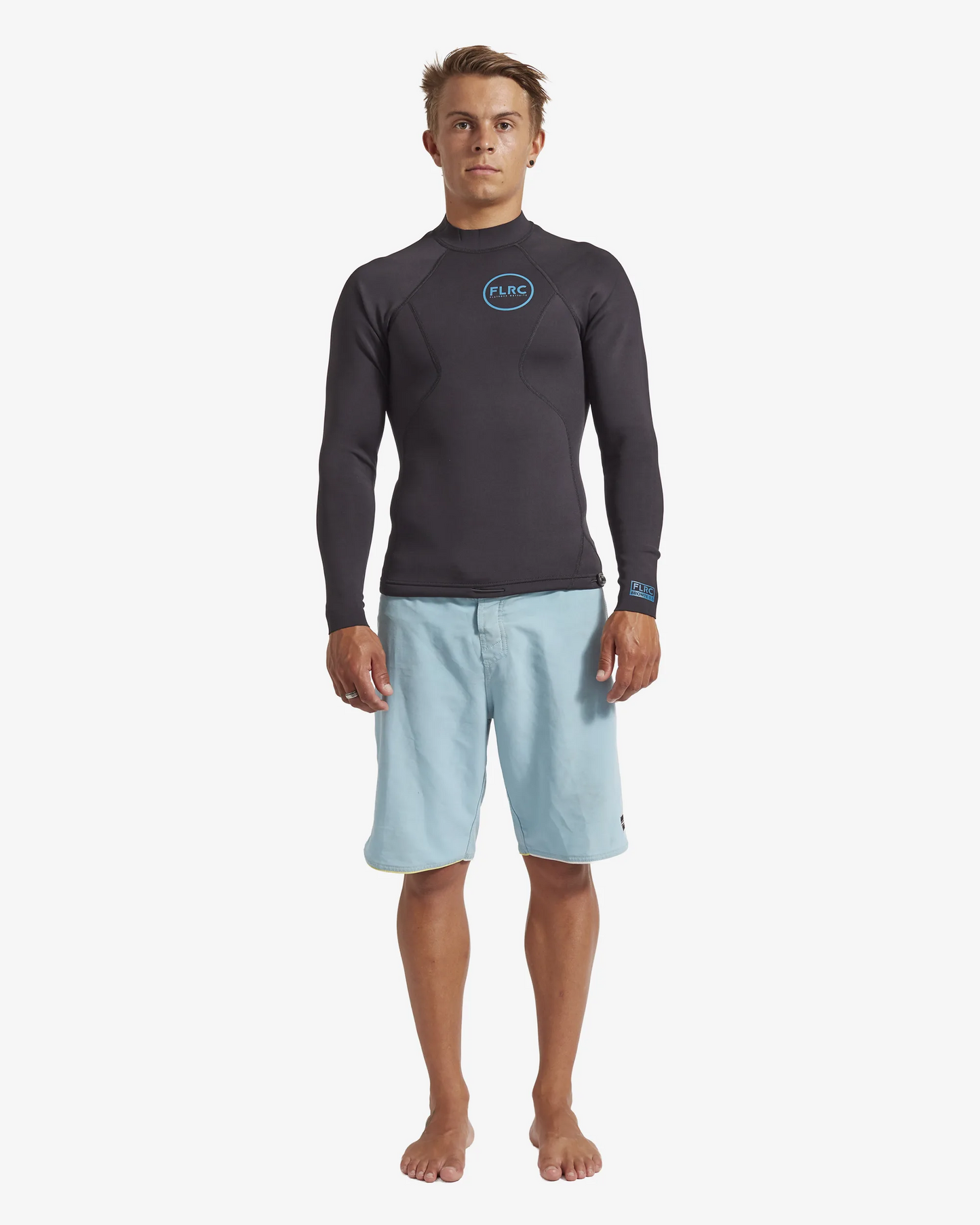 Man wearing black FLRC 1.5mm wetsuit top with blue logo, front view in studio.