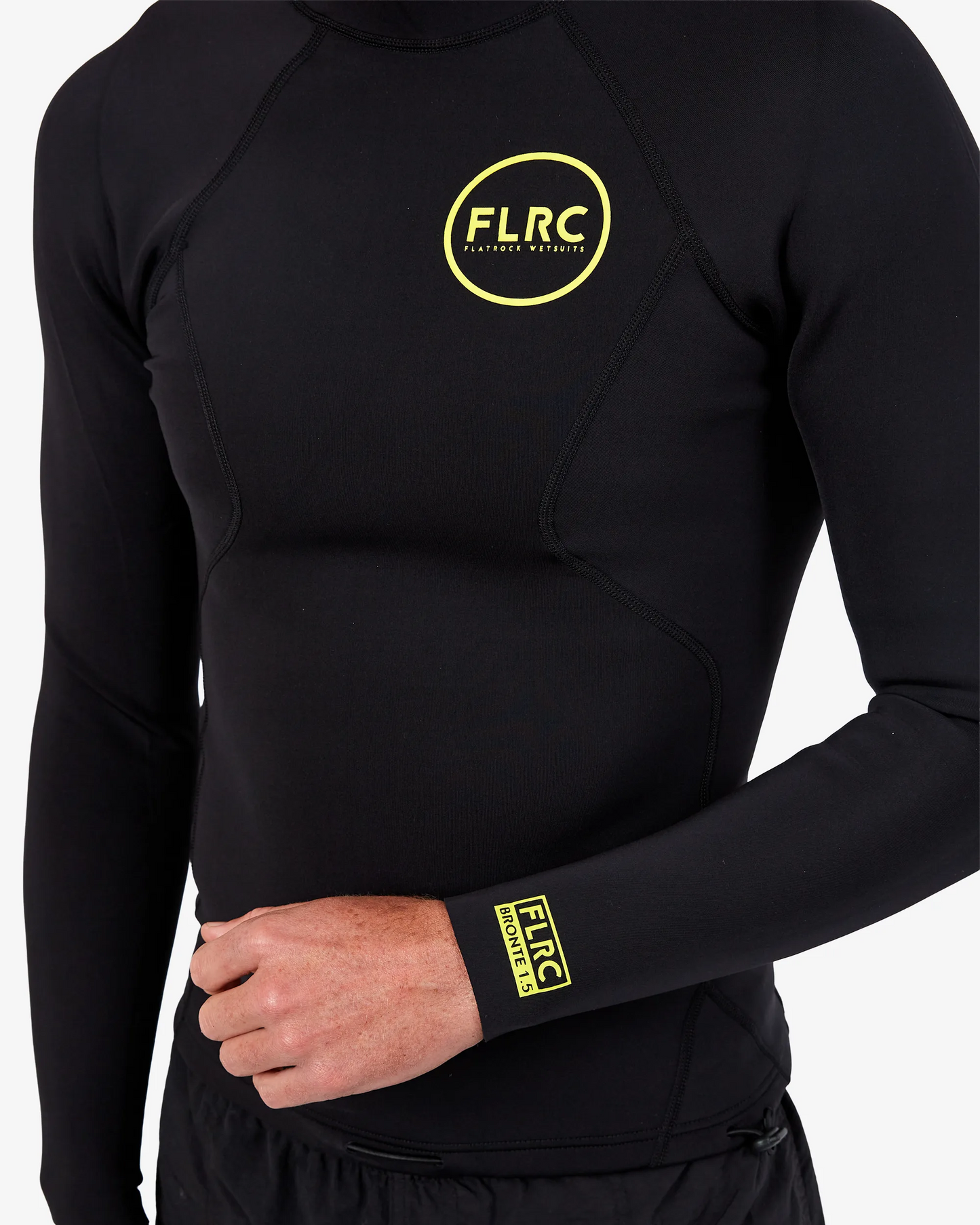 Close-up of black FLRC 1.5mm wetsuit top with yellow logo, showing front detail.