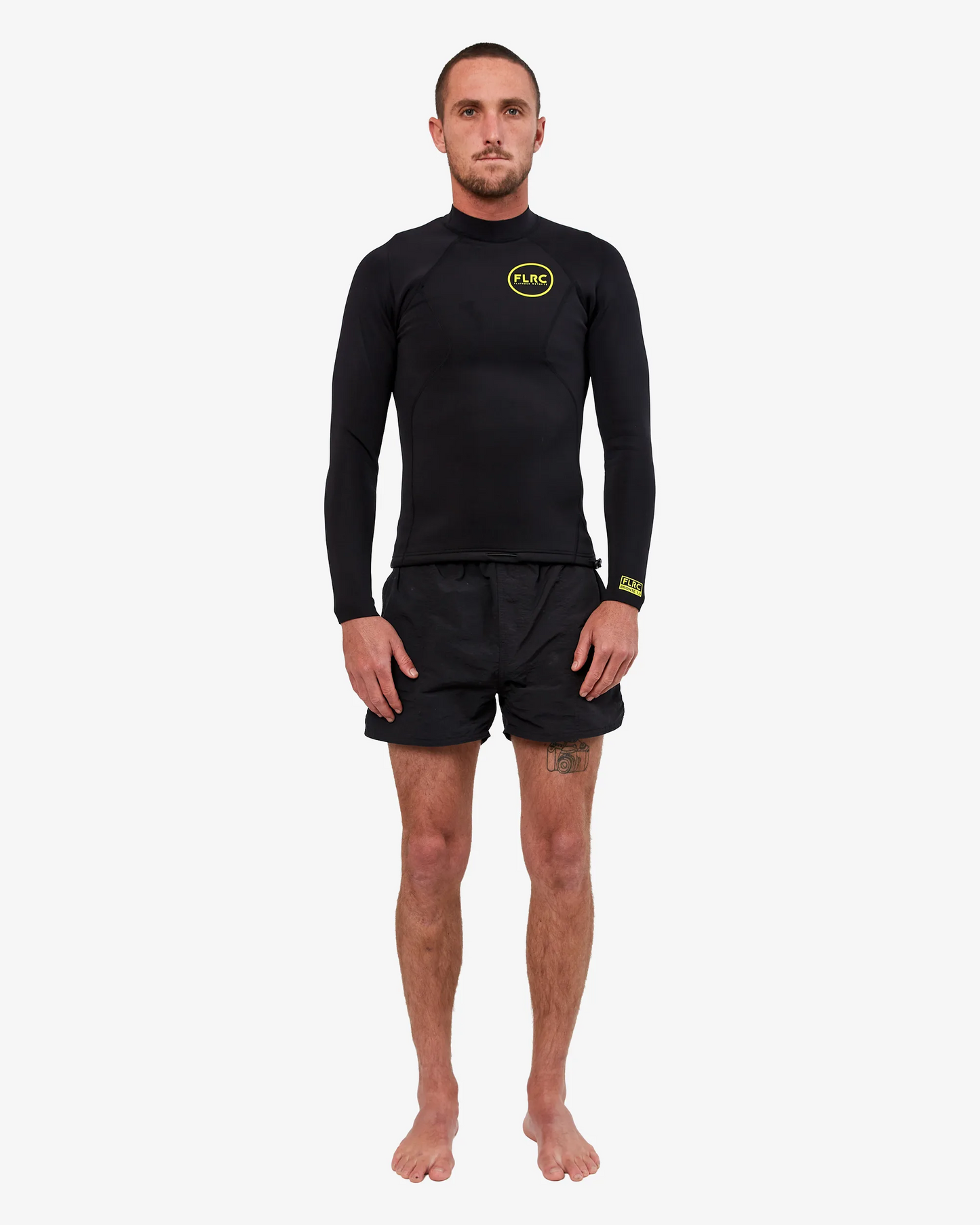 Man wearing black FLRC 1.5mm wetsuit top with yellow logo, front view in studio.