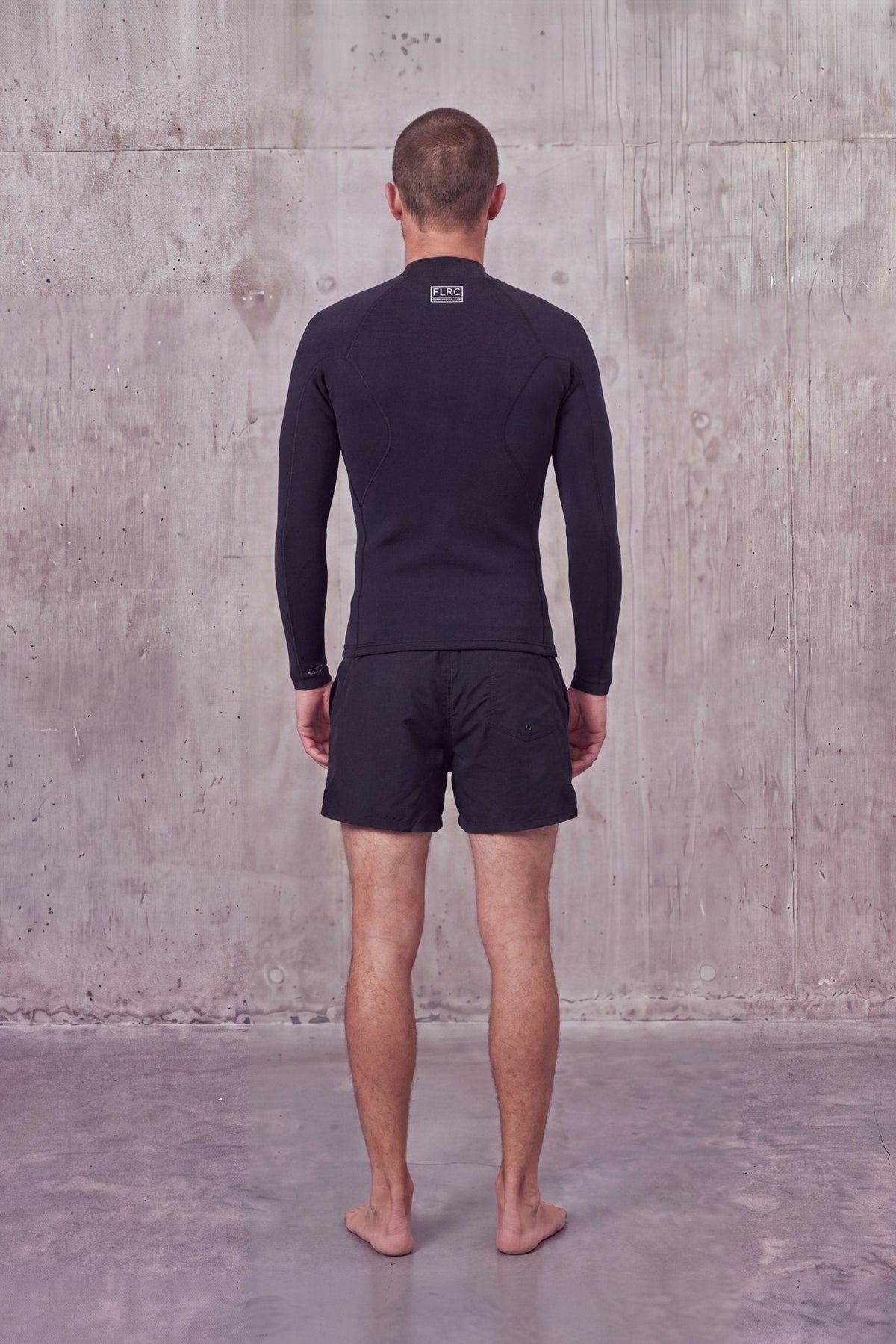 Back view of a man in the Men's 1.5mm Wetsuit Top V1 with small logo below the neck