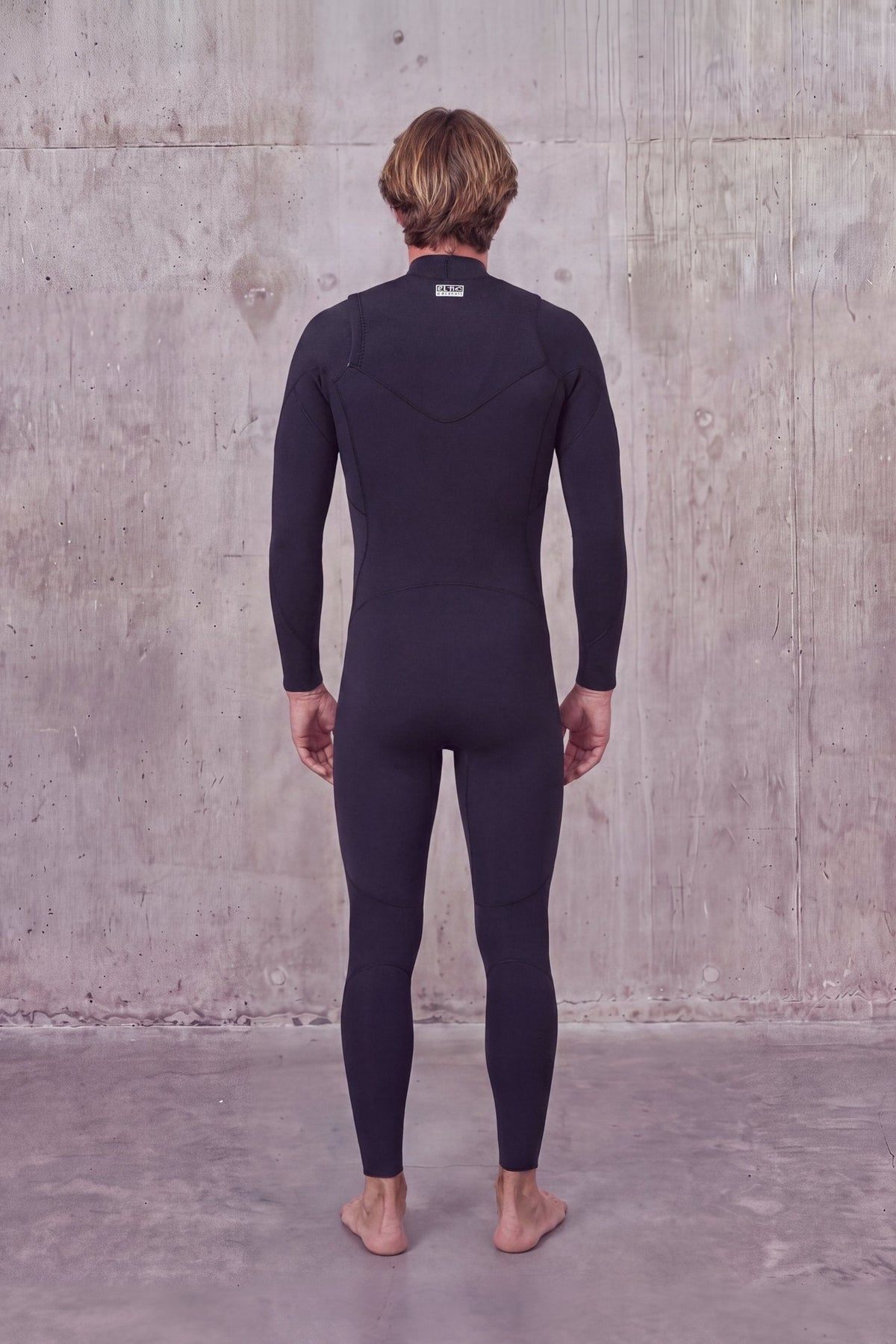 Back view of a man in the Men's 3/2mm Fullsuit V2 wetsuit with label at the back of the neck