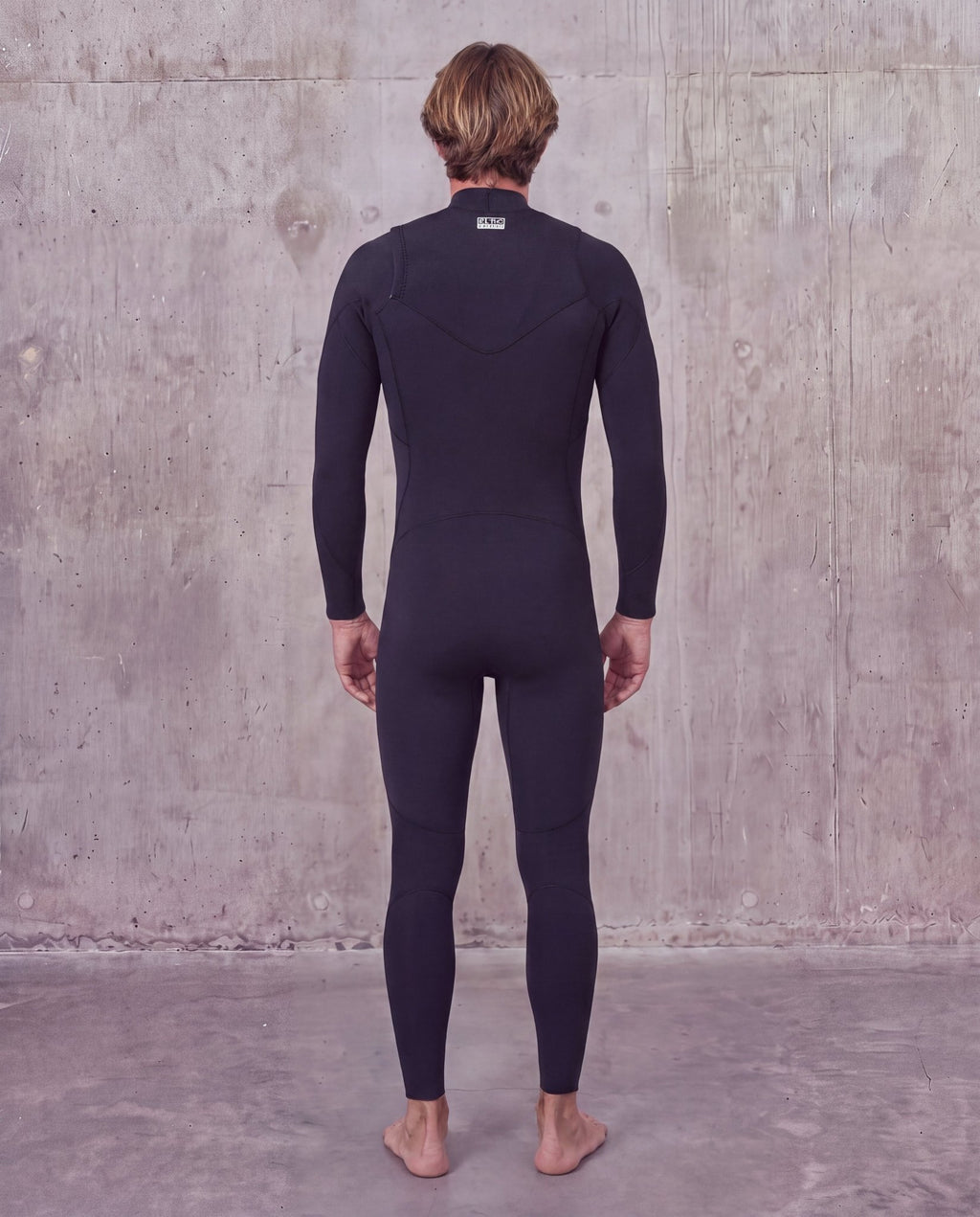 Back view of a man in the Men's 3/2mm Steamer V2 wetsuit with label at the back of the neck