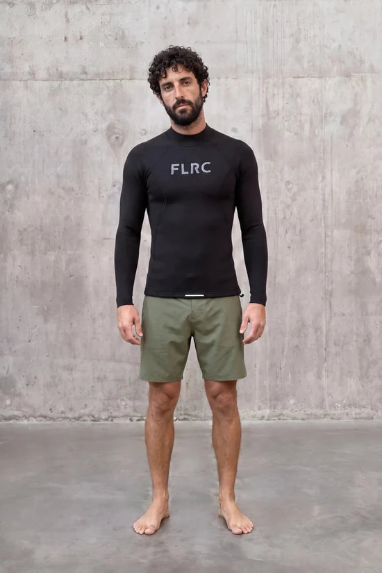 Model standing front-on against a concrete wall in the Men's 1.5mm Wetsuit Top V2